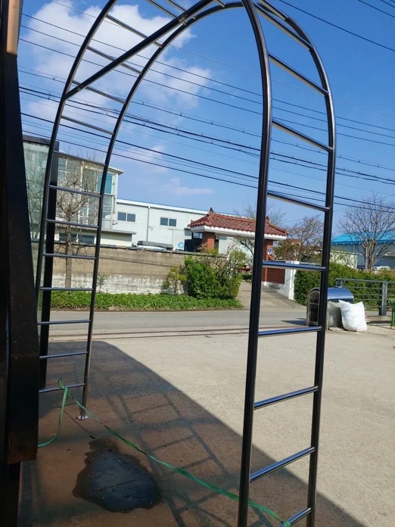 야외 공간에 설치한 스테인리스 간살 아치 구조물